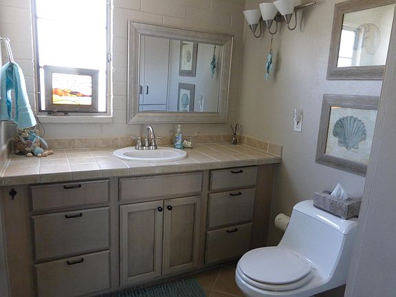 Bath with tile counters and linen closet not shown and another photo has full shower