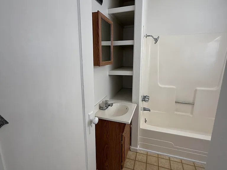 Entry to bath, sink/vanity, tub/bath combo, new vanity lights just installed so not in photo,