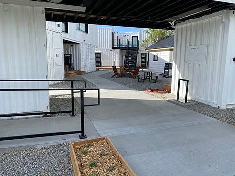 View through the front entryway opening into the courtyard with firepit, pizza oven, etc.