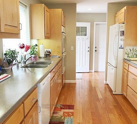 Hardwood floor from entry to kitchen with corian counters and flush mounted sink.  Deep drawers and pull out shelving make storage easy.