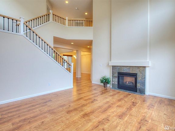 Formal living room. With double sided gas fireplace. Airy banister staircase to 2nd floor.