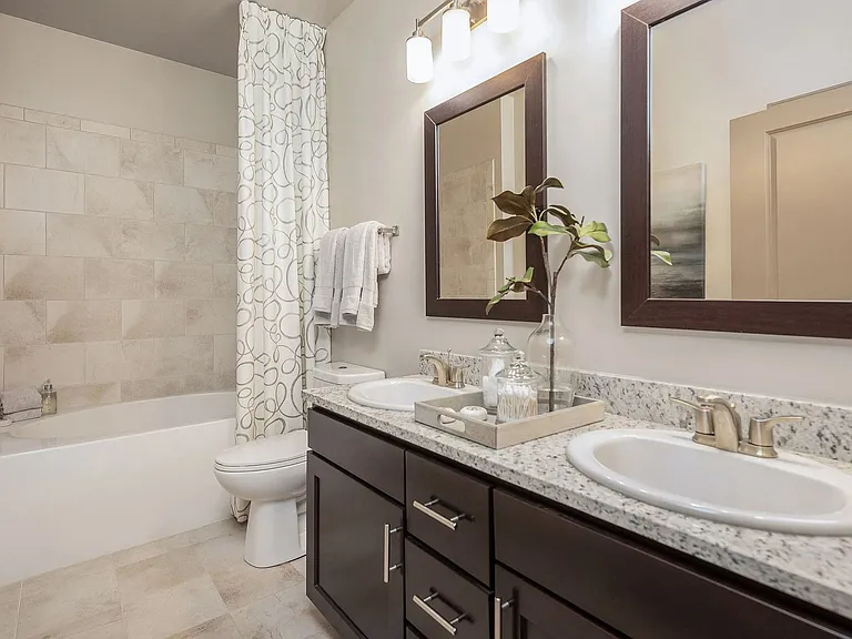 Modern bathroom with dual vanities, granite countertops, and updated finishescomfortable, stylish apartment living in Charlotte.