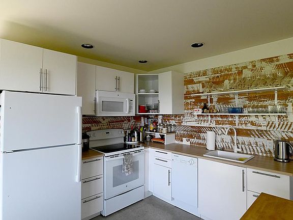 Kitchen with custom back splash. Dishwasher and microwave.