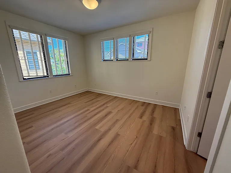 Spacious Bedroom #1 features multiple windows, vinyl flooring, walk-in closet, a separate bathroom sink and share a Jack-and-Jill style bathroom for the bathtub and toilet.