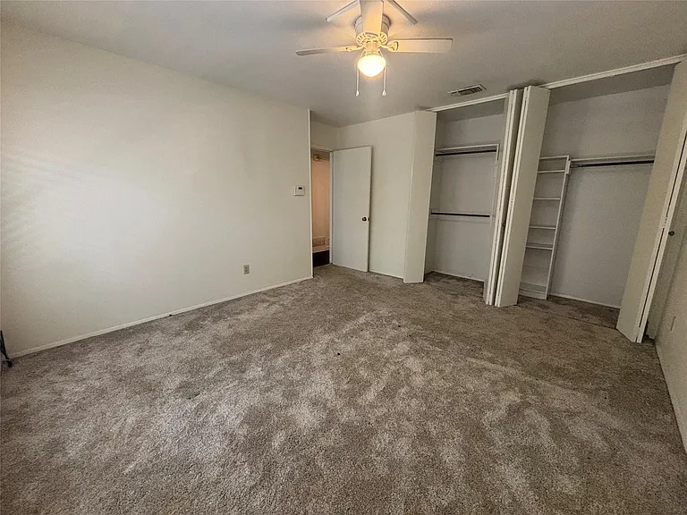 Spacious room with plush carpet flooring and neutral wall tones