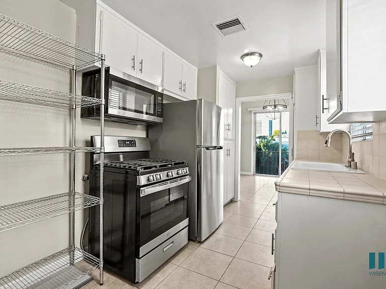 Kitchen with a Stainless-Steel Stove, Refrigerator, Microwave Oven, and Shelving
