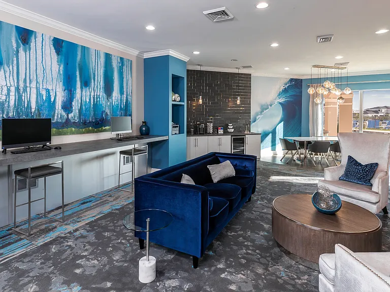 Resident clubhouse featuring a modern lounge, workstations, and stylish seating, a perfect place to catch up on some work.