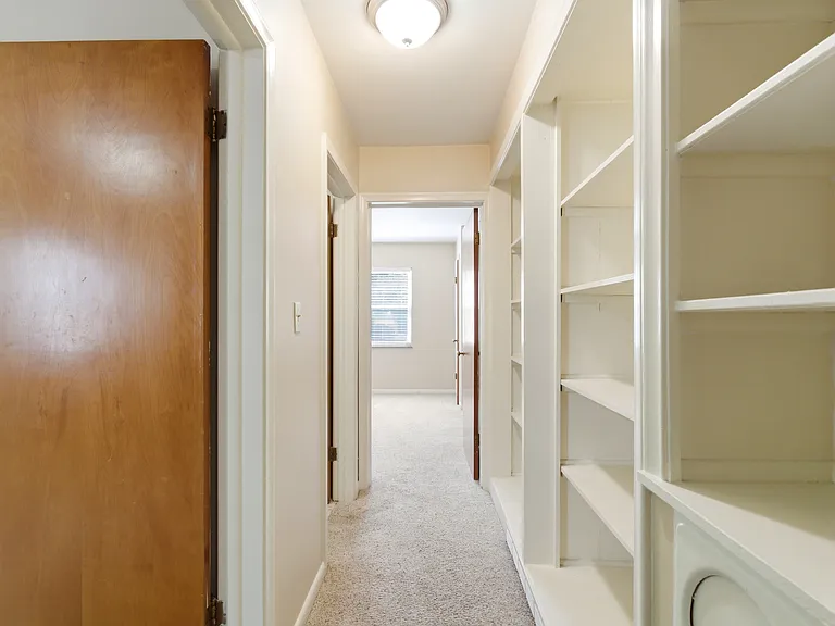 Heading to the bedrooms. Built-ins galore!! Great place for your stuff. (the round thing at the bottom is the laundry chute to the basement.)