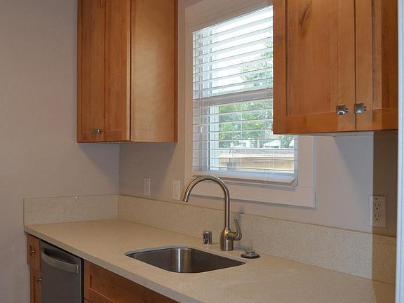 Remodeled kitchen with maple shaker cabinets, quartz counter top and tile floors, stainless steel appliances including a gas stove, refrigerator, dishwasher, garbage disposal.