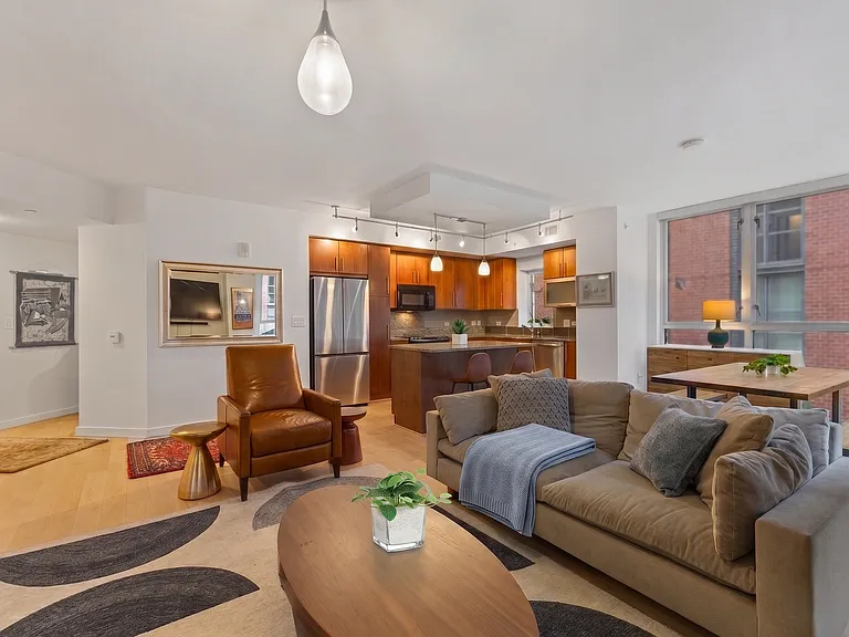 Relax in this stylish, open-concept living space featuring a chef-ready kitchen, warm mid-century modern accents, and floor-to-ceiling windows that flood the home with natural light.
