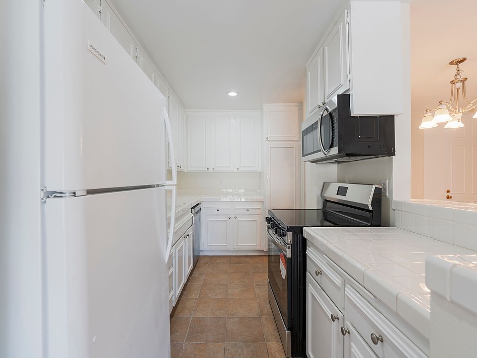 Kitchen with refrigerator, microwave, electric oven and stovetop, and dishwasher