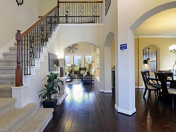 The staircase is complimented by elegant wrought iron railing, while a series of arches add interest