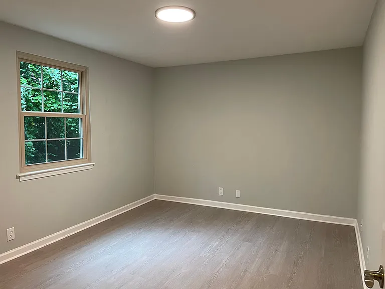 Spacious bedroom with large window.