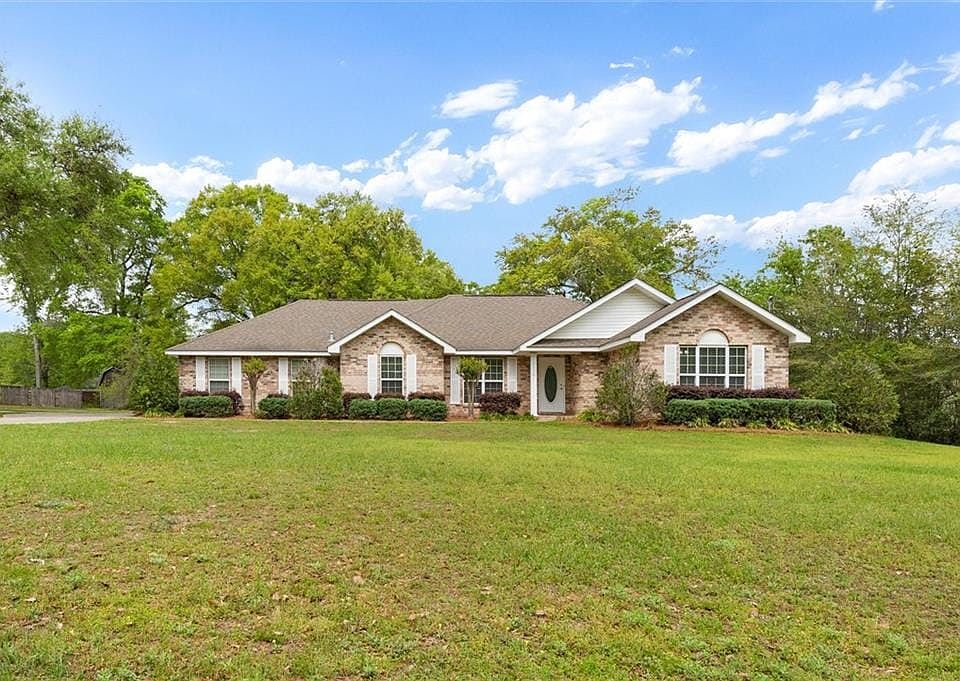 Single story home with a front yard and brick siding
