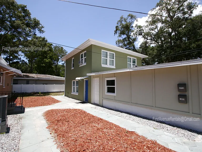 Exterior view of buildings, green is apartments, kaki is separately occupied long term tenants in main house and cream is landlords private storage.