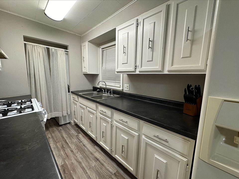 Kitchen with washer/dryer unit behind curtain in utility space
