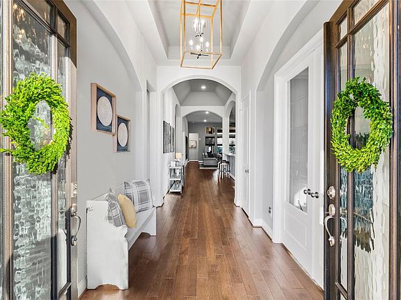 Lovely entry with beautiful light fixture and wood floors that continue throughout the main living areas of the home.