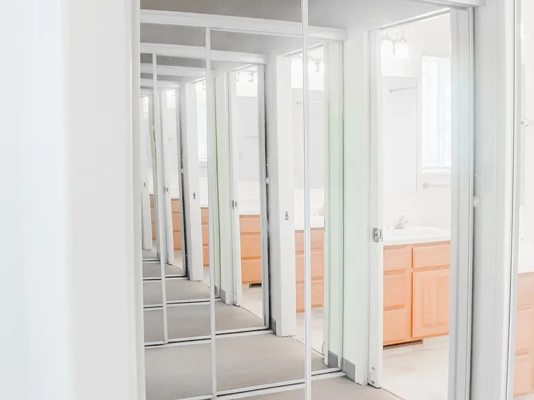 2 closets in master bedroom with mirror doors