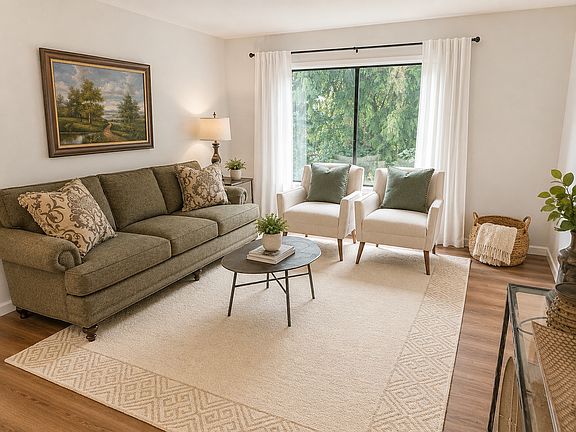 Spacious living room with 70" TV, luxury furnishings, and view of trees, private and comfortable!