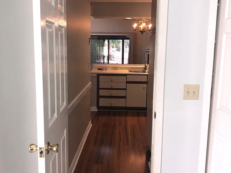 Kitchen hallway leads to 3rd bedroom with vaulted ceilings. The 3rd bedroom would be great as a private office.