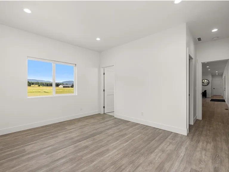 The main-level primary suite features beautiful mountain views, a spacious walk-in closet, and a luxurious private ensuite bathroom designed with elegant finishes and a relaxing atmosphere.
