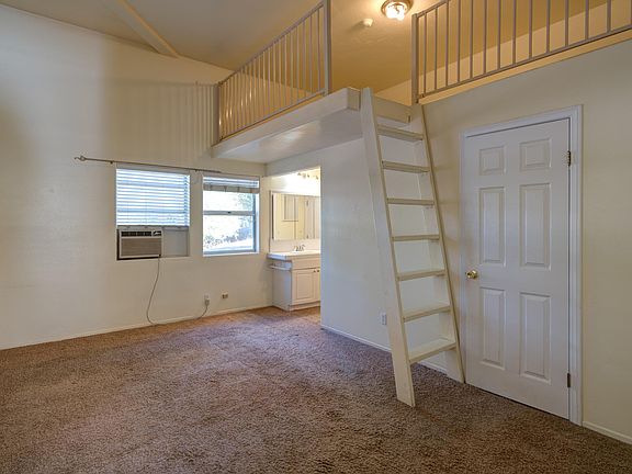 Bedroom with storage loft. Closet door to right. Vanity outside shower and toilet room.