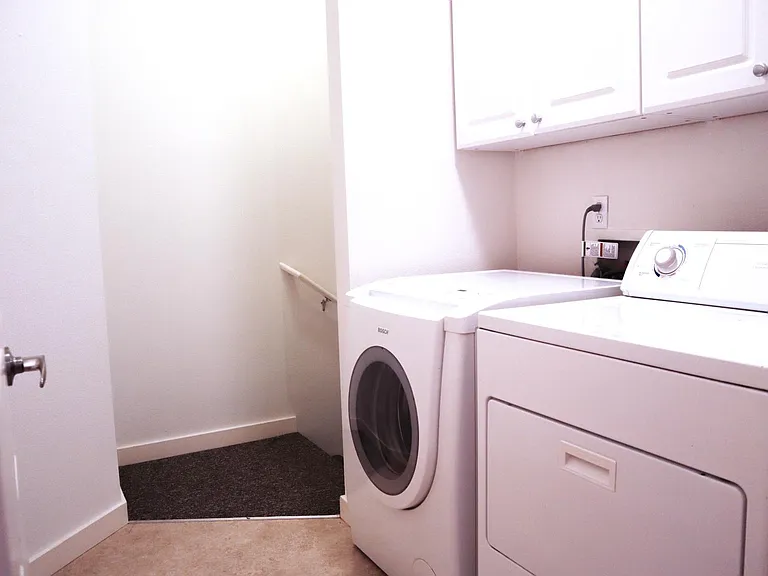 Laundry room with washer, dryer and storage cabinets.