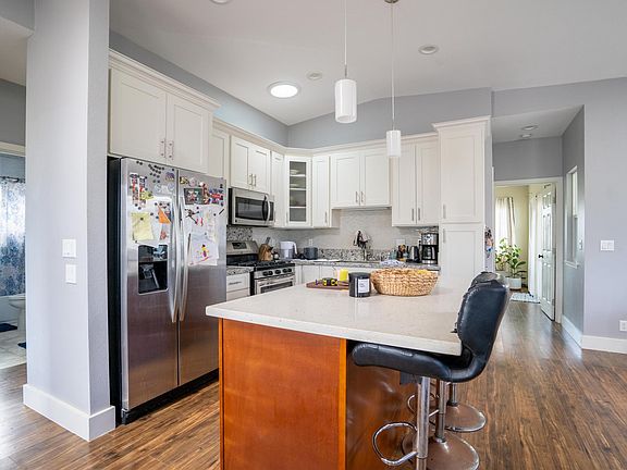Kitchen with island that has room for 3 bar stools. Notice the hallway to right leads to master bedroom. Which allows complete separation between master bedroom and the other two bedrooms.