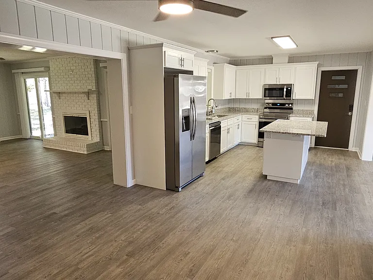 From Eating area - looking toward kitchen & Den. Kitchen Island has space for 4 chairs (1 on short side + 3 on land side)