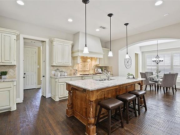 The kitchen is huge with today's colors of granite and cabinets with a large island, gas cook top, and opens to the breakfast nook.