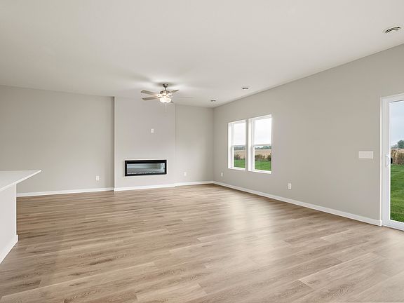 The family room is spacious with a ceiling fan and fireplace.