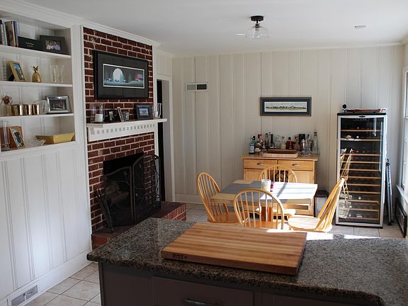 Dining area with fireplace and built-in shelving - opens to kitchen