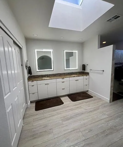 Sunny Master Bath with skylight and LED mirrors. Also has a water closet