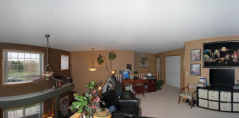 Another view of the oversized loft surrounded by windows and natural lights over looking the living room.