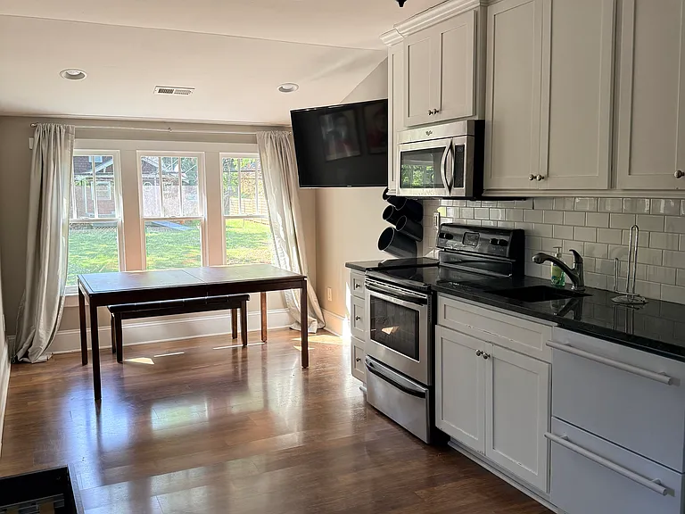 Dining Area, Kitchen with Sink, Range, Microwave and small fridge and freezer (pictured on far right)