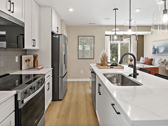Cook and prep with ease in this kitchen featuring stainless steel appliances and an island sink.