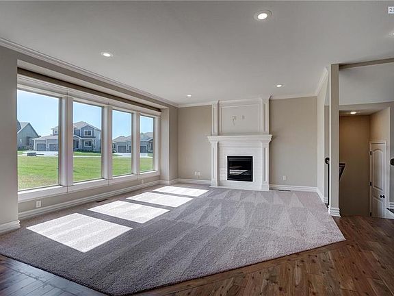 Light open an airy Great Room with gas fireplace , trimmed mantle and floor to ceiling windows.