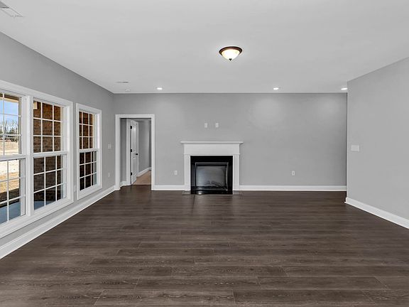 The open concept Claremont plan is filled with natural light and showcases an electric fireplace. En