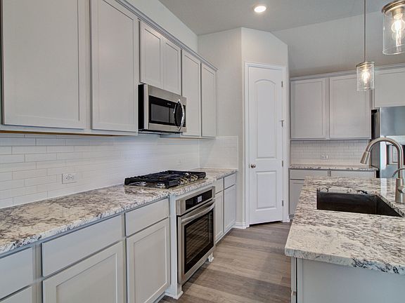 Kitchen Featuring Pendant Lighting, Stunning Countertops, Stainless Steel Appliances, Gas Cooking