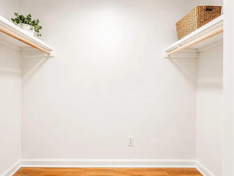 Walk-in closet with double hanging rods and open shelving, offering ample space to organize clothing and accessories.