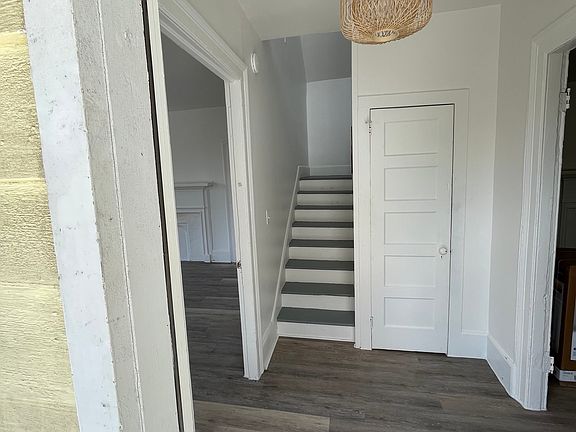 Entry foyer w/ master bedroom to left and living room and kitchen to the right w/ 2 additional bedrooms up the stairs