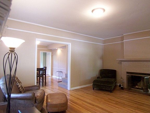 Large living room features cozy fireplace and warm hardwood floors