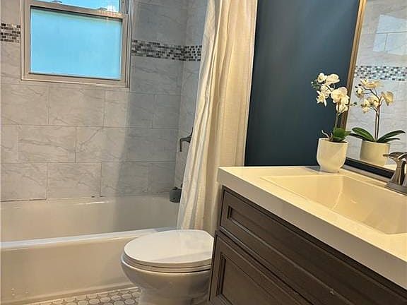Elegant tile details and a modern vanity define this beautifully updated bathroom space.