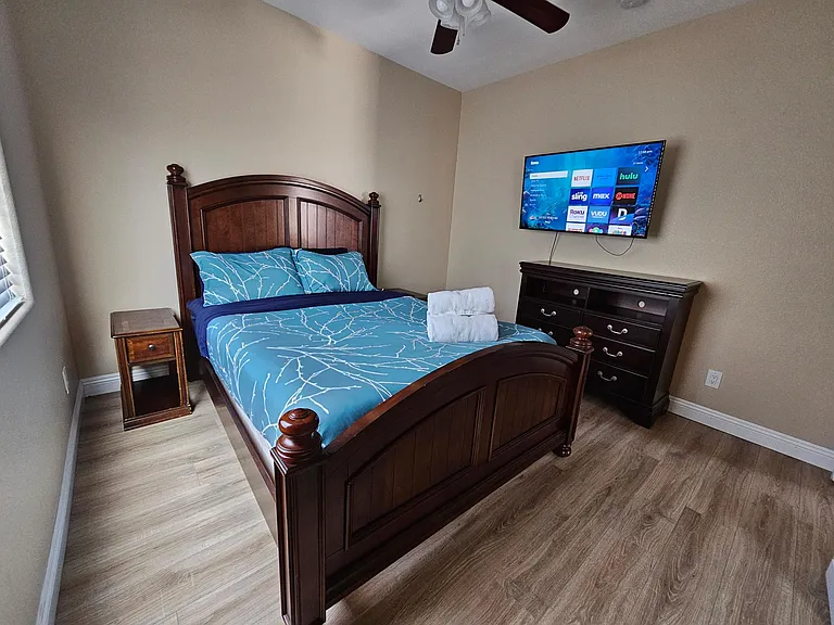 Bedroom 2 - television, queen bed, dresser, 2 night stands and ceiling fan and closet.