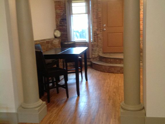 View of the dining/kitchen from living room. Door opens to small court and rear alley side entrance.