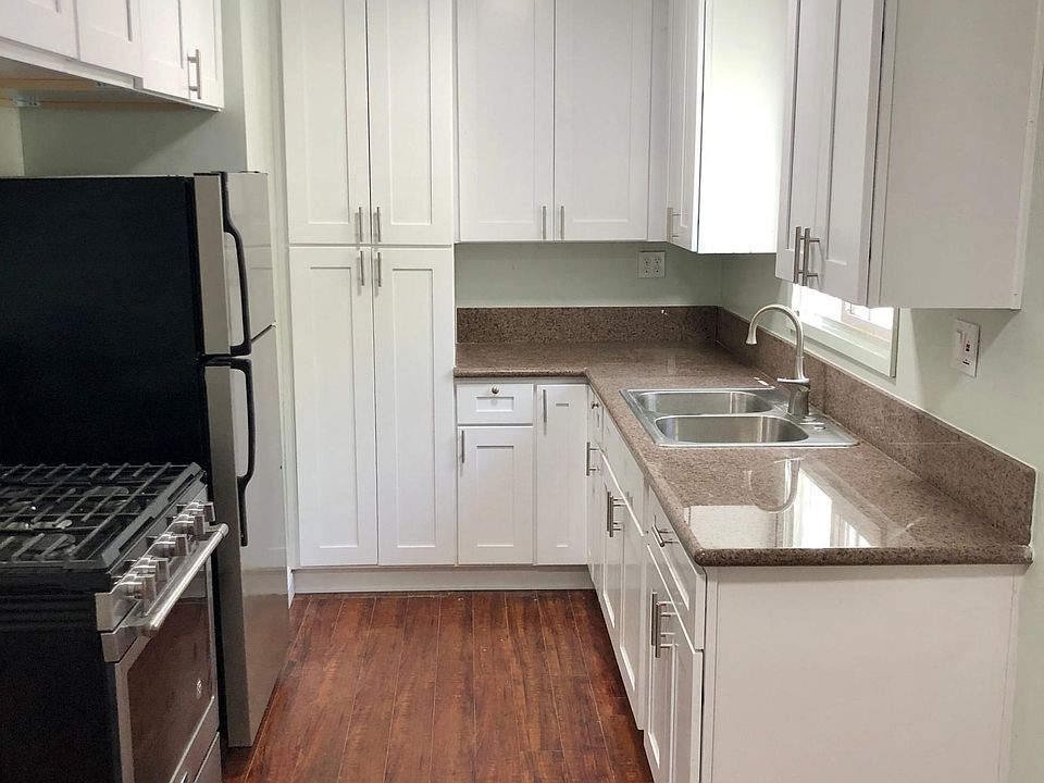 Updated kitchen with new stainless steel appliances and white cabinetry