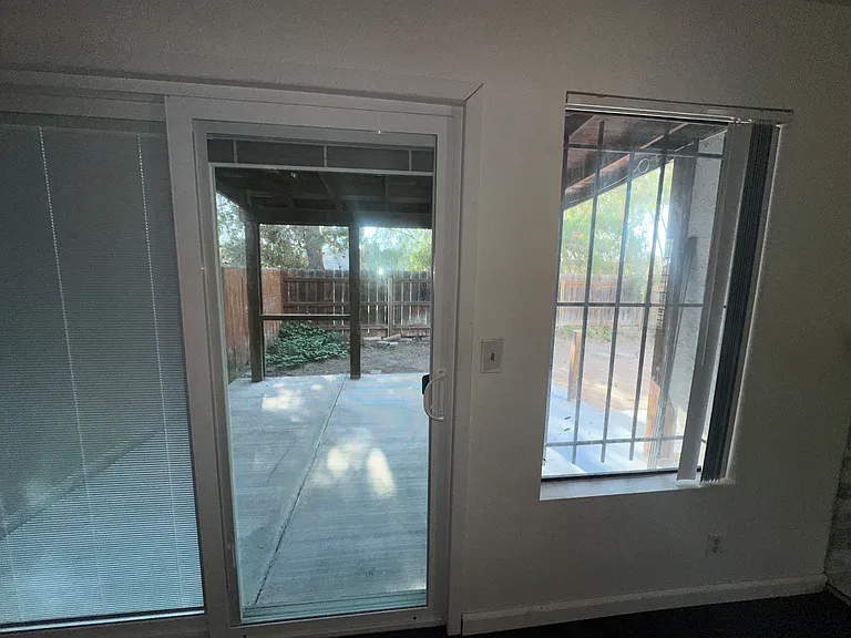 New screen doors with built in shades in the up position, view of backyard from living/dining area.