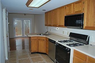 Kitchen w/oak cabinets, tile flooring, & gas range