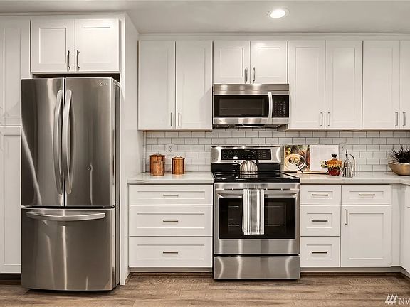 Kitchen with quartz countertops, stainless steel appliances, and custom cabinetry