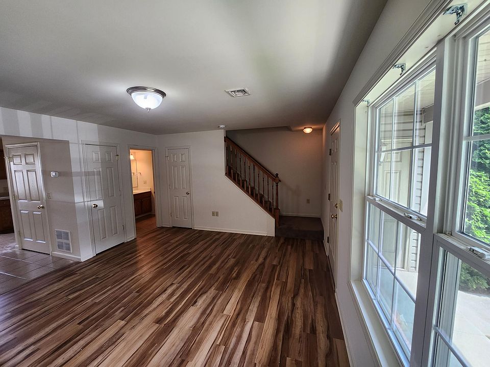 Living Room (15'8" x 13'6"), viewing entrance to dining/kitchen and powder room (with stack washer/dryer)